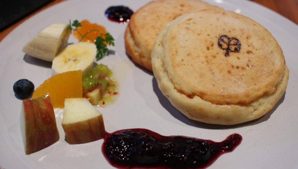 Vegan pancakes served with fruit and sauce.